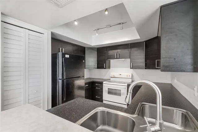 a kitchen with stainless steel appliances granite countertop a refrigerator and a sink