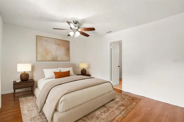 a bedroom with a bed and wooden floor