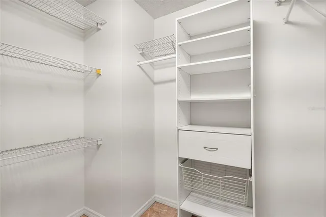 a view of walk in closet with empty racks