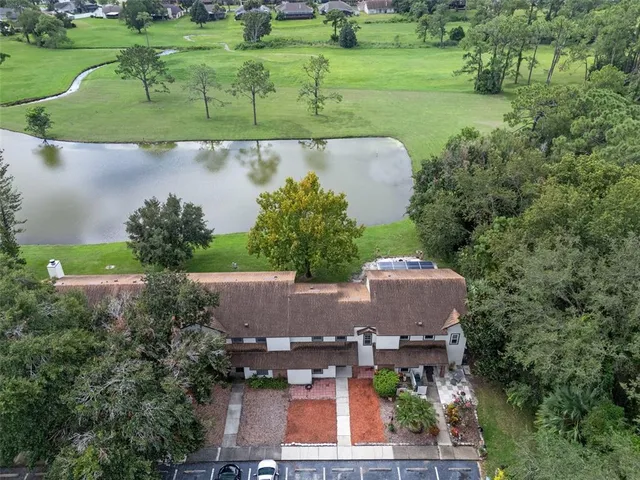 an aerial view of a house with a yard and lake view