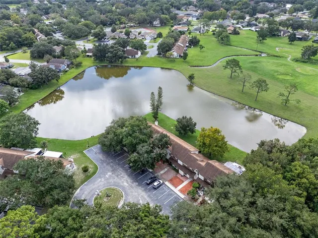 an aerial view of a residential houses with outdoor space and lake view