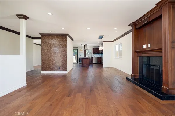a view of empty room with kitchen and fireplace