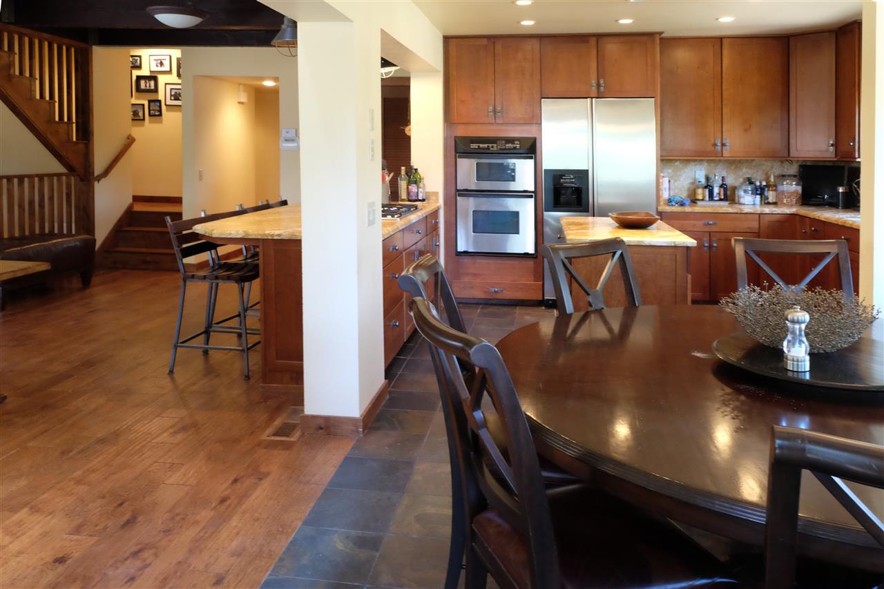 334 Davison Road Mammoth Lakes, CA 93546 - Photo 6 of 15 a kitchen with stainless steel appliances granite countertop a table chairs refrigerator and sink