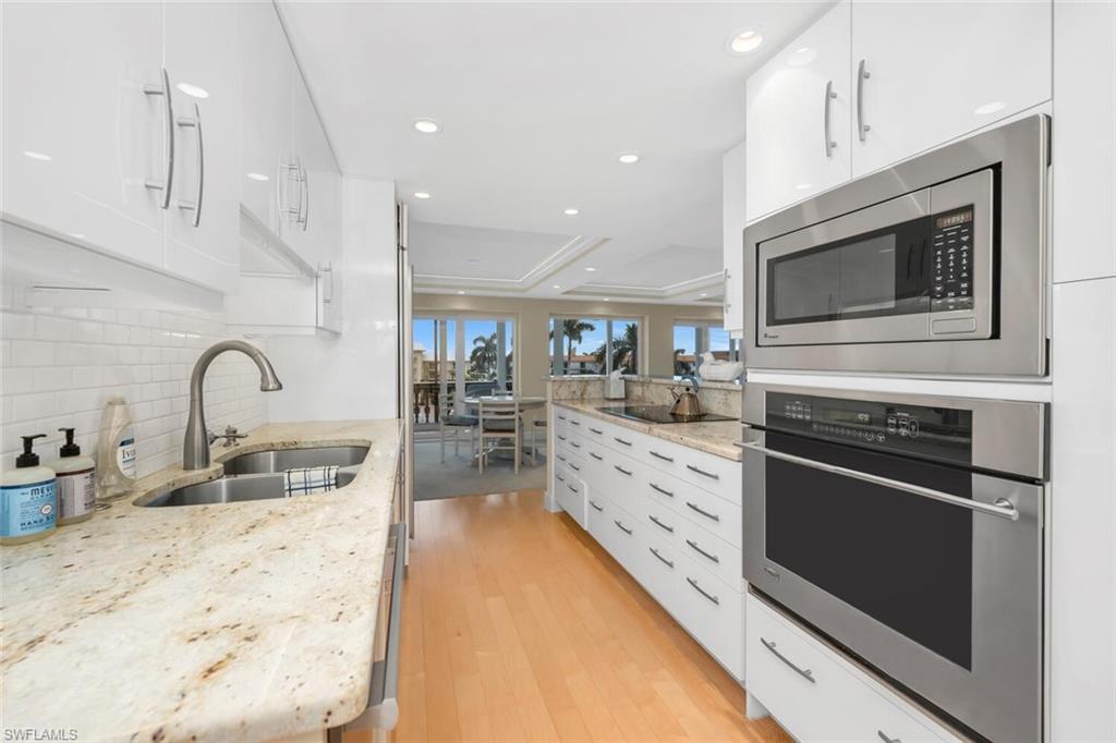 a kitchen with stainless steel appliances kitchen island granite countertop a stove a sink and a microwave