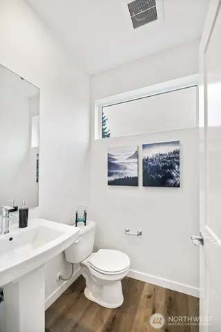 a bathroom with a toilet a sink and mirror