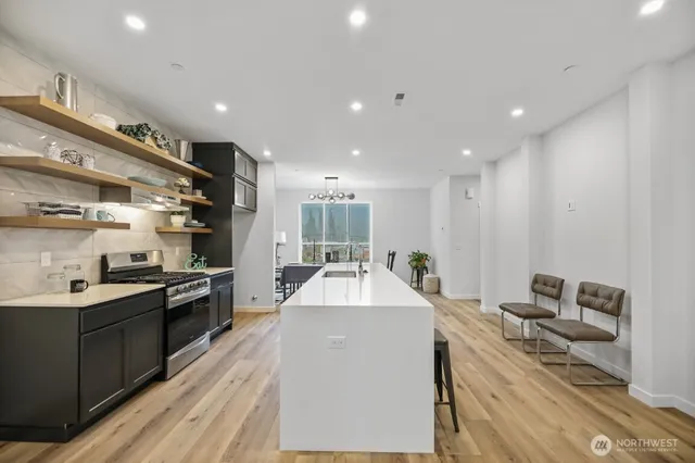 a large kitchen with kitchen island a sink stainless steel appliances and a counter top space