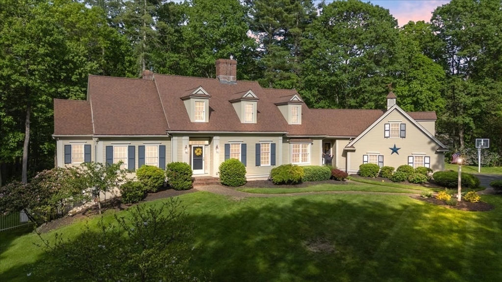 a front view of a house with a yard and green space