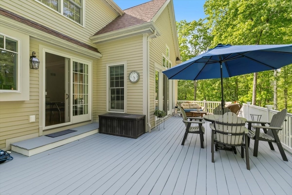 9 Perley Lane Boxford, MA 01921 - Photo 6 of 41 a view of a roof deck with table and chairs under an umbrella