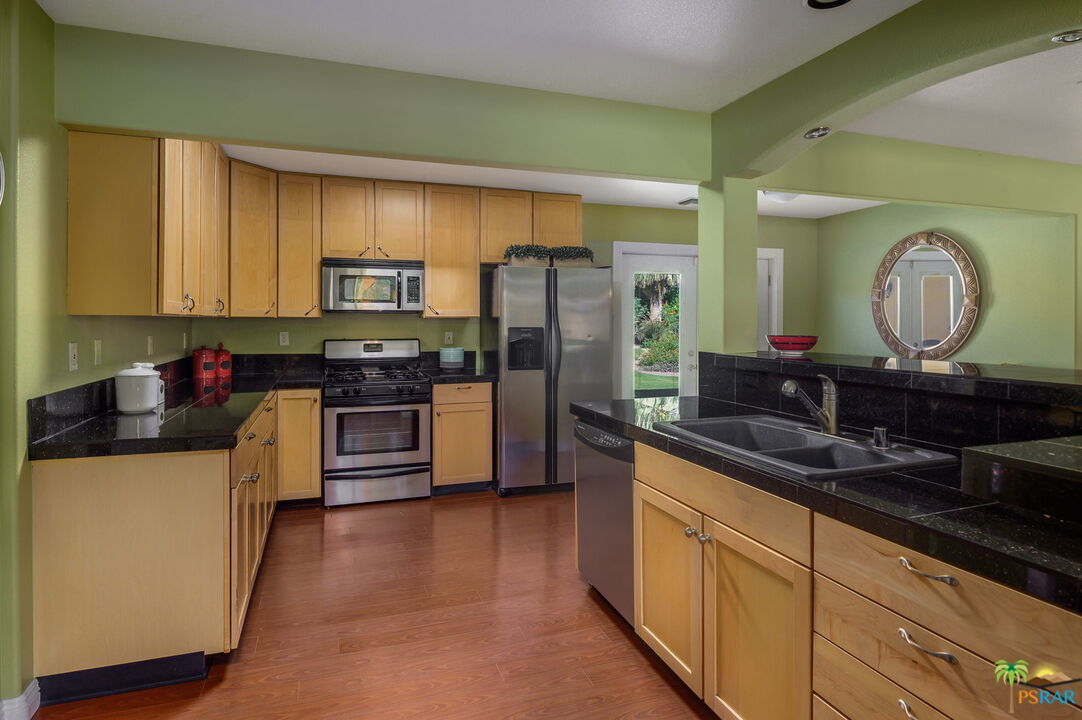 38851 Nielson Road Rancho Mirage, CA 92270 - Photo 35 of 50 a kitchen with stainless steel appliances a sink cabinets and a refrigerator