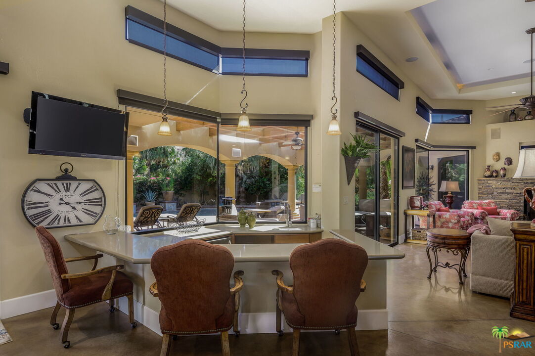 38851 Nielson Road Rancho Mirage, CA 92270 - Photo 7 of 50 a dining room with furniture a rug a flat screen tv and a large window