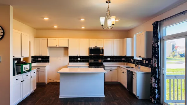 a kitchen with a sink a counter space appliances and cabinets