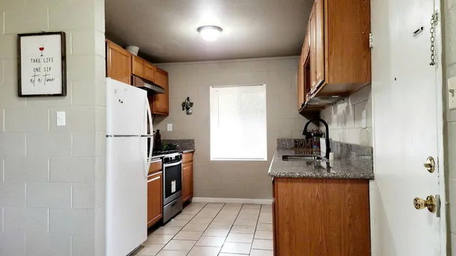 a kitchen with stainless steel appliances granite countertop a refrigerator and a sink