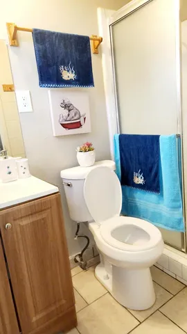 a white toilet sitting next to a bathroom sink and a mirror
