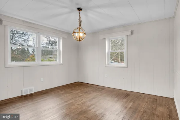 a view of empty room with wooden floor and window
