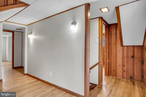 a view of a hallway with wooden floor and staircase