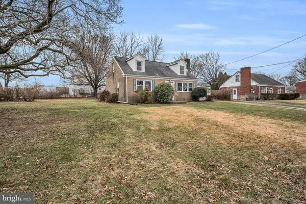 a view of a big house with a big yard and large trees