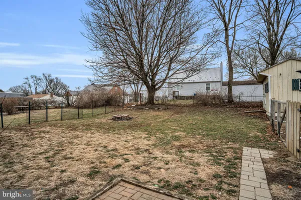 a view of a yard with wooden fence and a bench