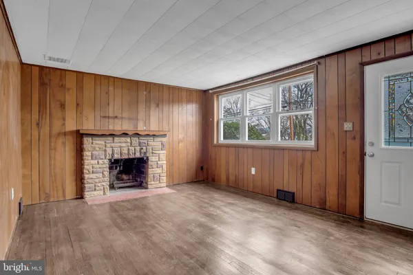 an empty room with windows and fireplace