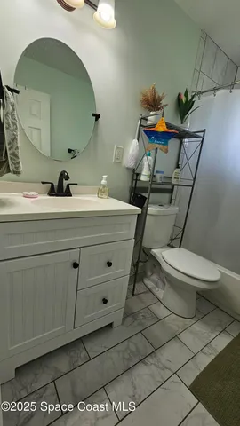 a bathroom with a sink mirror vanity and toilet