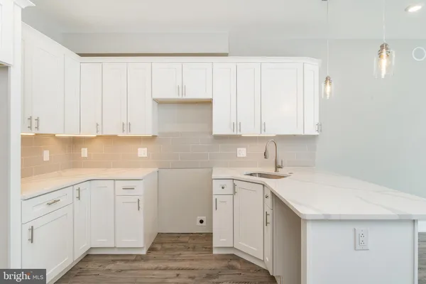 a kitchen with white cabinets appliances and sink