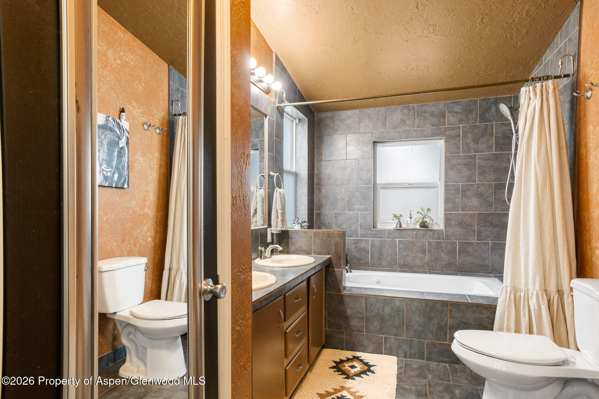 106 Cedar Circle Parachute, CO 81635 - Photo 22 of 35 a bathroom with a granite countertop sink toilet a mirror and a bathtub