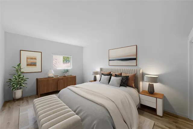 a bedroom with a large bed and a potted plant