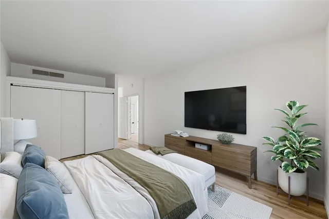 a bedroom with a flat screen tv and a potted plant