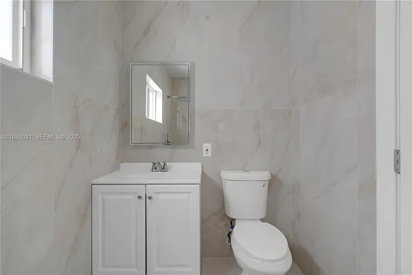 a bathroom with a toilet sink and mirror