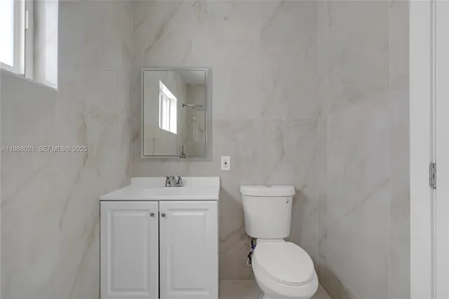 a bathroom with a toilet sink and mirror