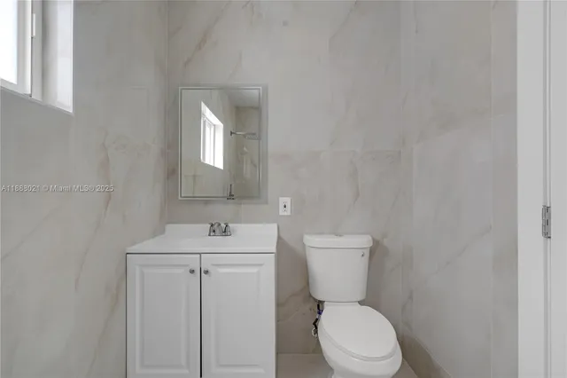 a bathroom with a toilet sink and mirror