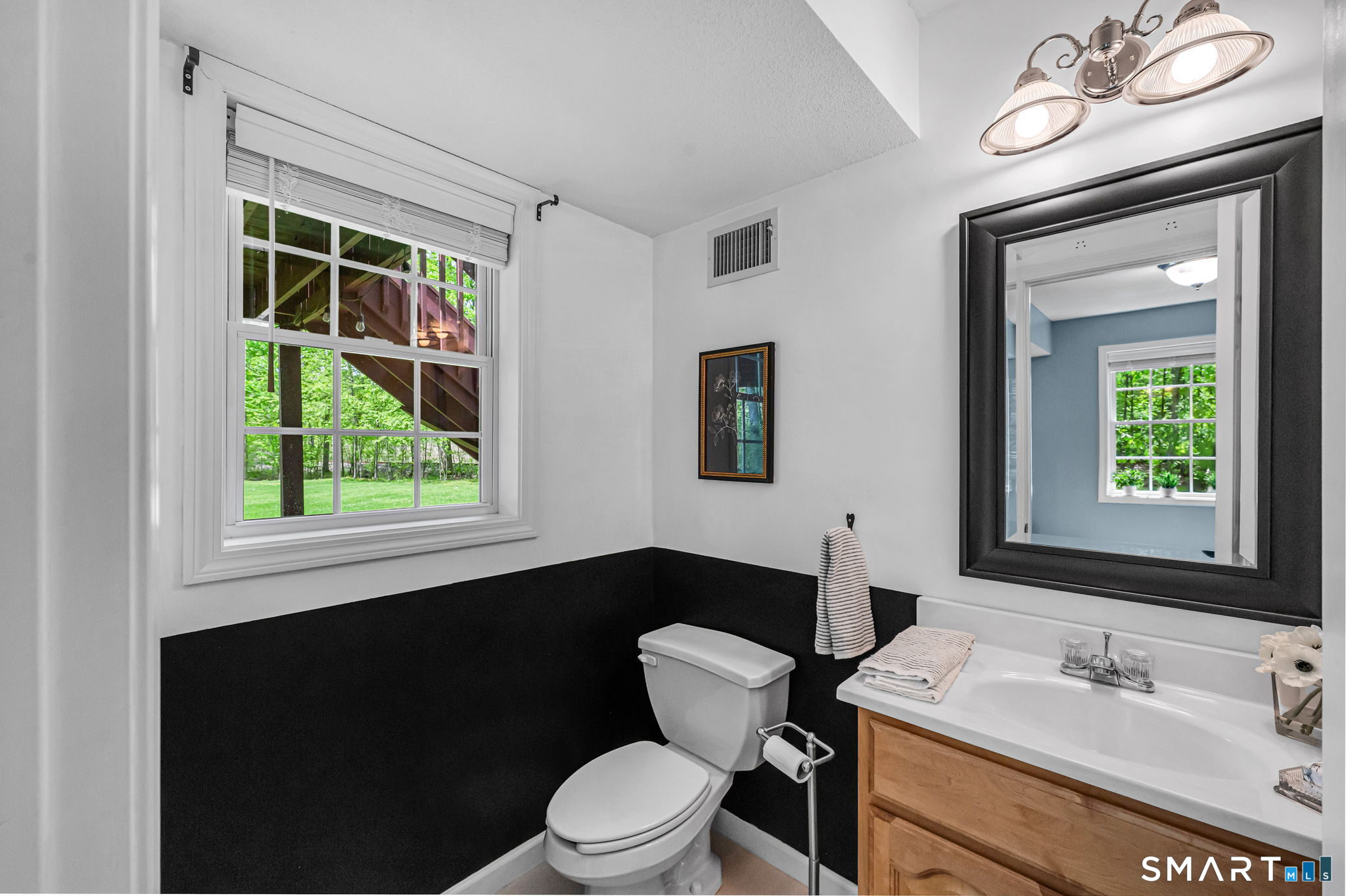 1001 Suffield Street Suffield, CT 06078 - Photo 22 of 30 a bathroom with a toilet sink vanity and mirror