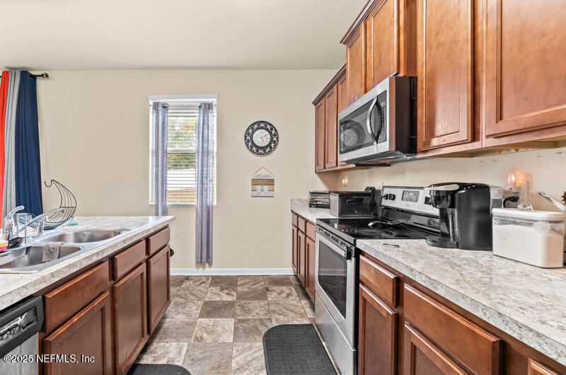 4076 Great Falls Loop Middleburg, FL 32068 - Photo 14 of 30 a kitchen with stainless steel appliances granite countertop a sink stove and cabinets