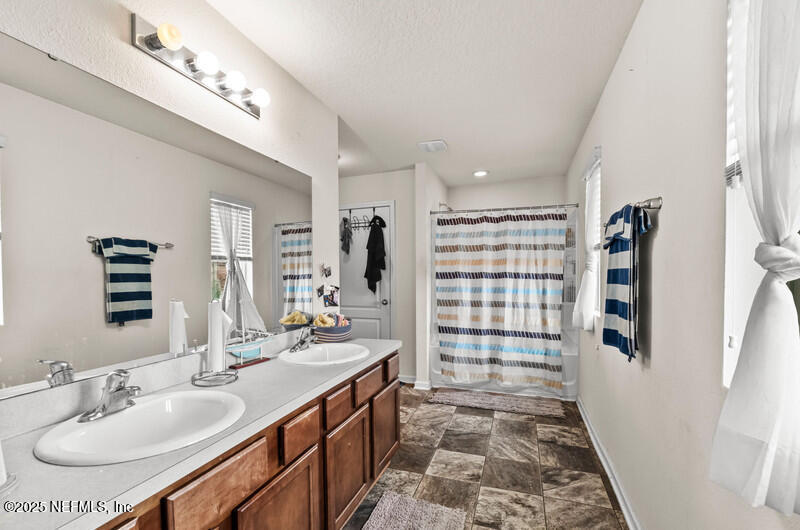 4076 Great Falls Loop Middleburg, FL 32068 - Photo 20 of 30 a bathroom with a sink double vanity and a shower