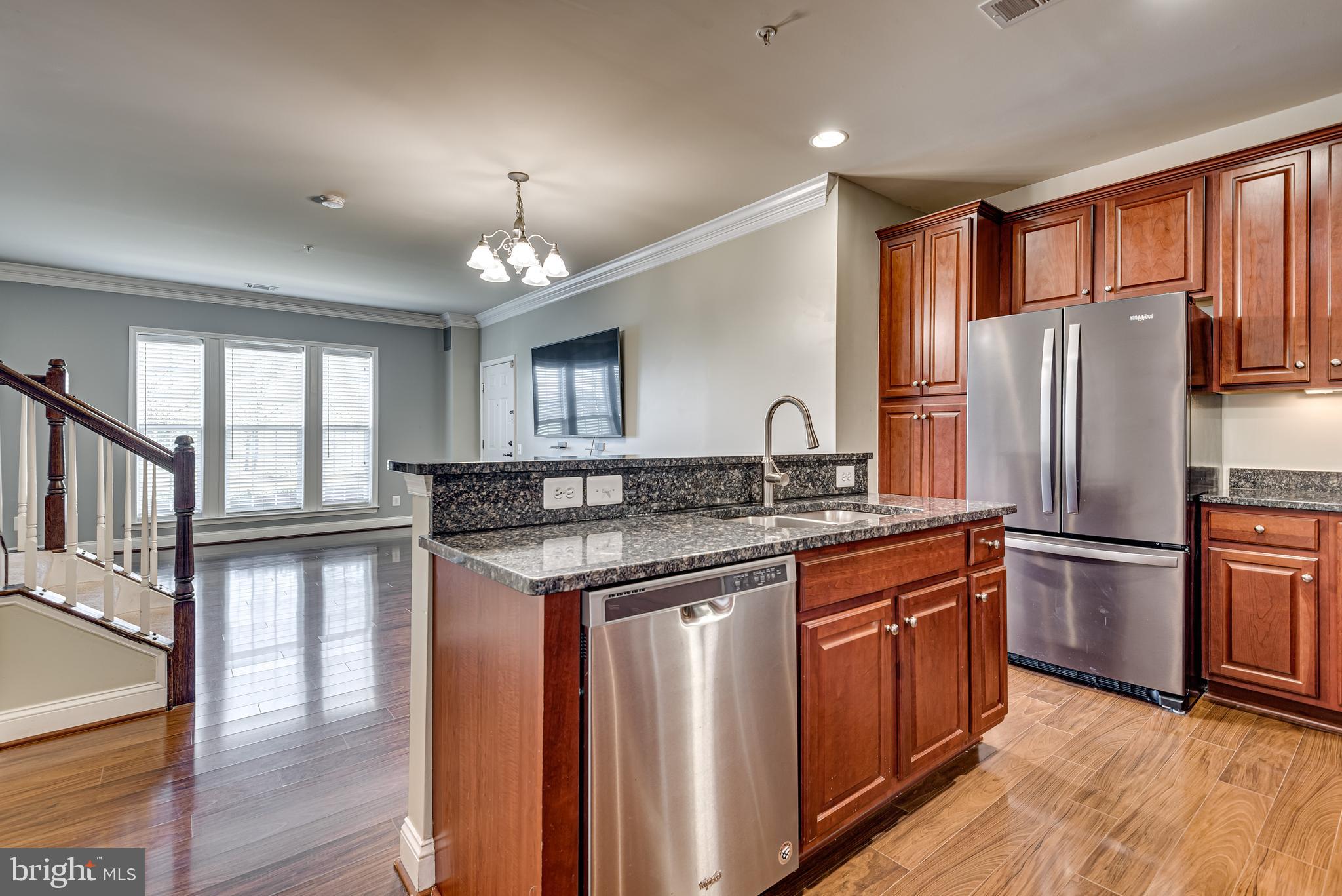 20654 Sibbald Square Ashburn, VA 20147 - Photo 16 of 43 a kitchen with stainless steel appliances granite countertop a refrigerator a sink dishwasher a stove and white countertops with wooden floor