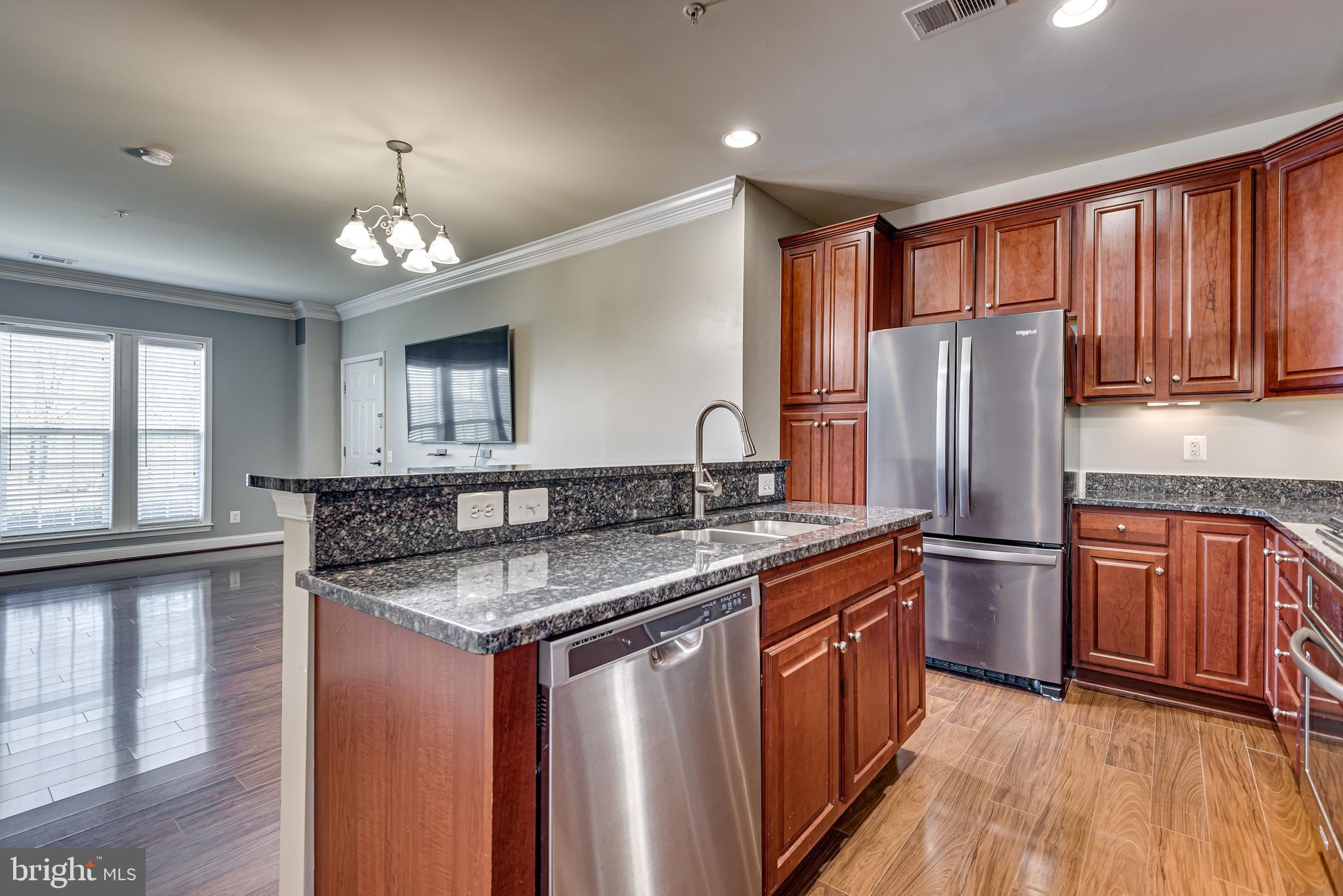 20654 Sibbald Square Ashburn, VA 20147 - Photo 17 of 43 a kitchen with stainless steel appliances granite countertop a refrigerator a sink dishwasher a stove and white countertops with wooden floor