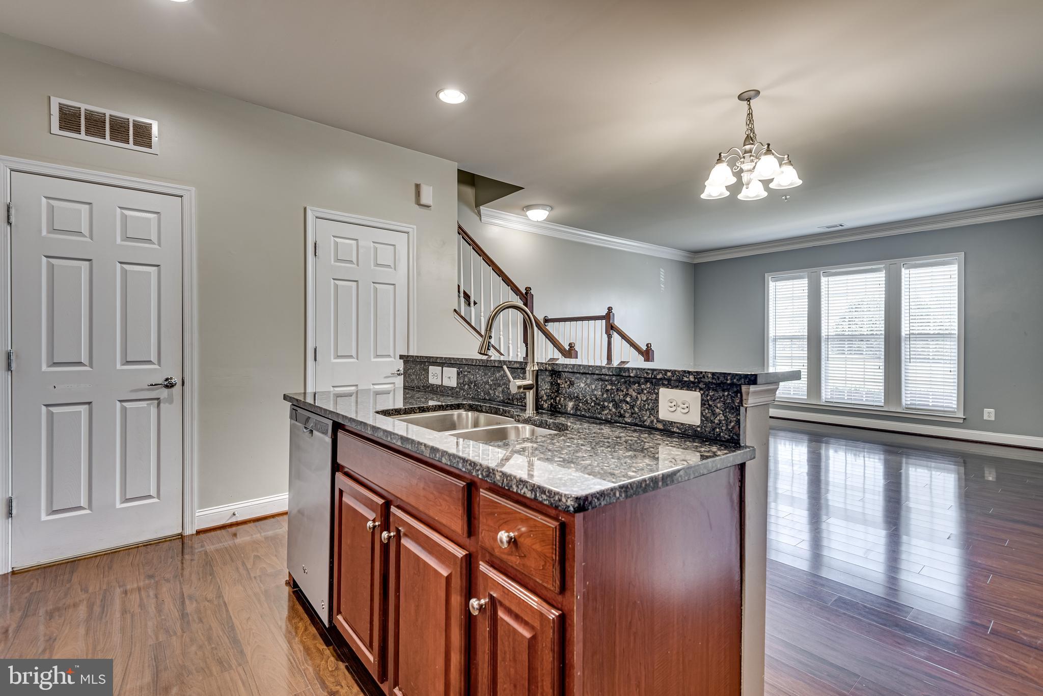 20654 Sibbald Square Ashburn, VA 20147 - Photo 18 of 43 a kitchen with stainless steel appliances granite countertop a sink stove and wooden floor
