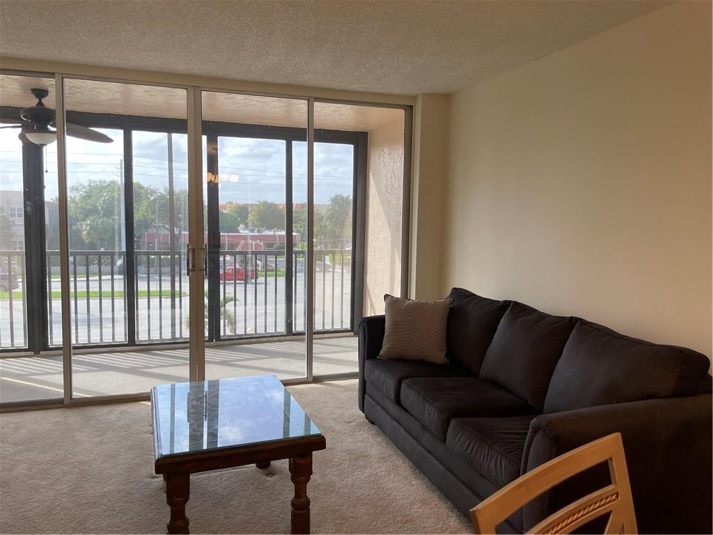 740 South Federal Highway, Unit 312 Pompano Beach, FL 33062 - Photo 7 of 43 a living room with furniture and a floor to ceiling window