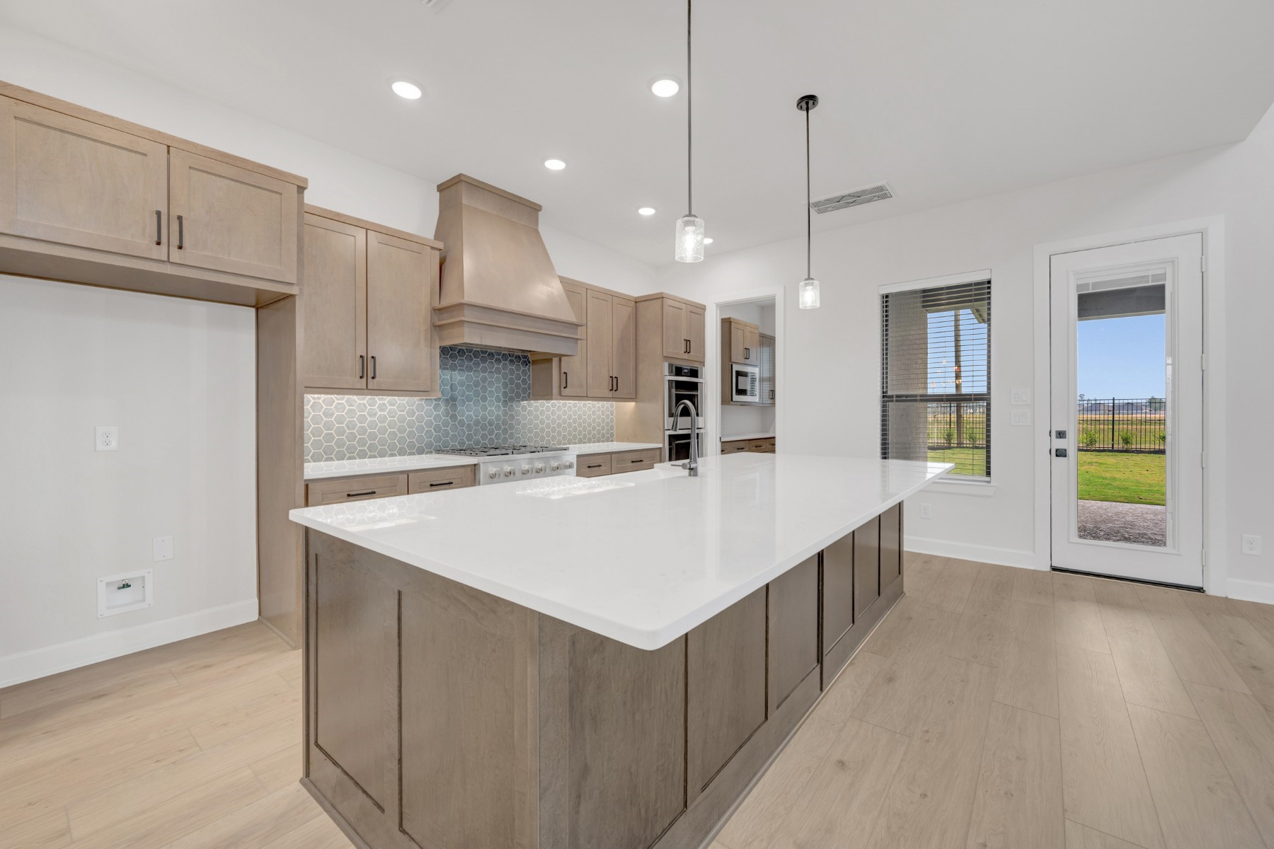 18019 Lobos Point Lane Conroe, TX 77302 - Photo 28 of 49 a large kitchen with kitchen island a stove a sink a refrigerator and a wooden cabinets