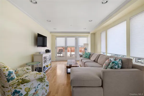 a living room with furniture a flat screen tv and a window