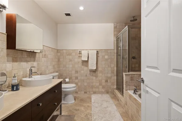 a bathroom with a double vanity sink toilet and shower