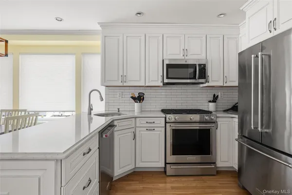 a kitchen with white cabinets and stainless steel appliances