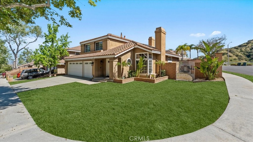 1671 Dominguez Ranch Road Corona, CA 92878 - Photo 4 of 42 Situated on a corner lot, this property offers an expansive front lawn, established trees, and a gated side yard for added privacy and functionality.