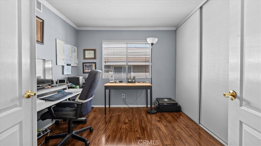1671 Dominguez Ranch Road Corona, CA 92878 - Photo 26 of 42 A versatile room with wood flooring and a window for natural light, perfect for use as a home office, guest room, or additional bedroom.