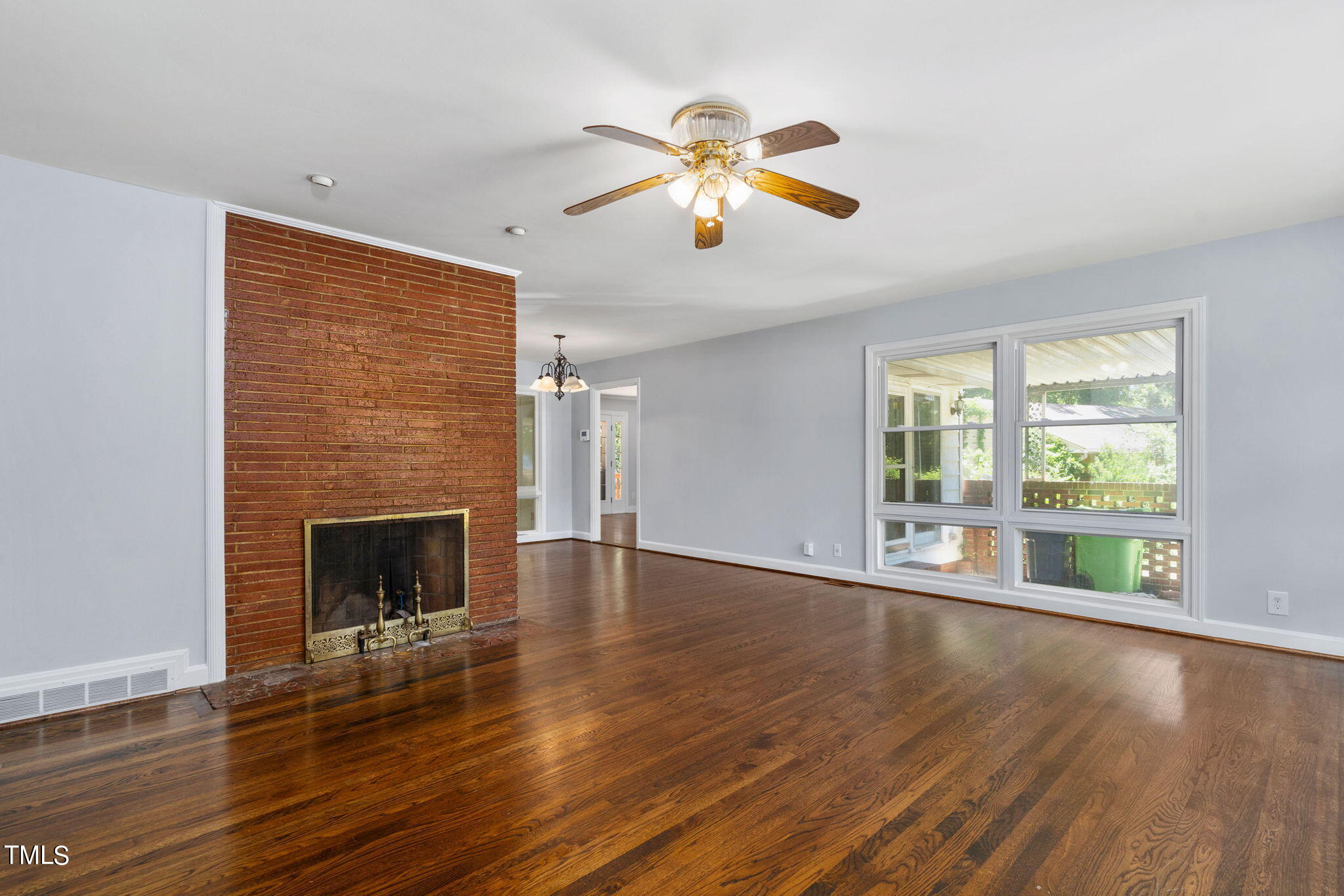126 Clarendon Crescent Raleigh, NC 27610 - Photo 15 of 40 a view of an empty room with wooden floor and a window