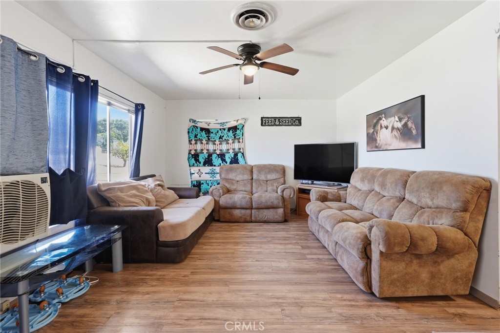 183 East County Line Road Calimesa, CA 92320 - Photo 4 of 31 a living room with couches and a flat screen tv with wooden floor