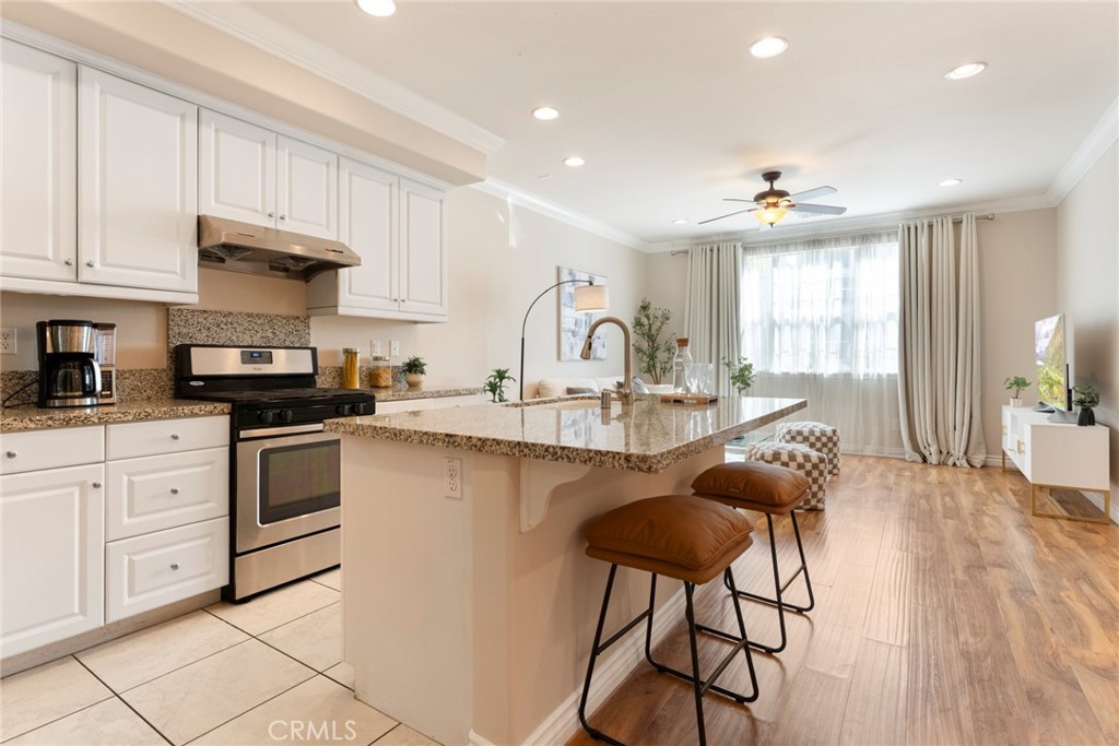 869 East Mountain Way, Unit D Azusa, CA 91702 - Photo 11 of 55 a kitchen with granite countertop white cabinets and stainless steel appliances