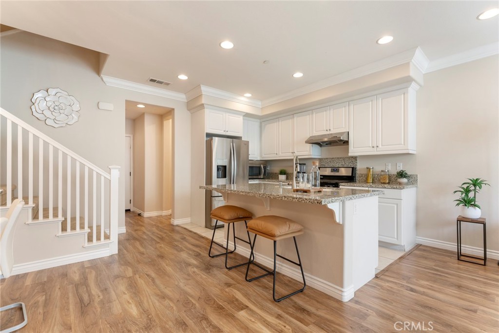 869 East Mountain Way, Unit D Azusa, CA 91702 - Photo 9 of 55 a kitchen with white cabinets and stainless steel appliances
