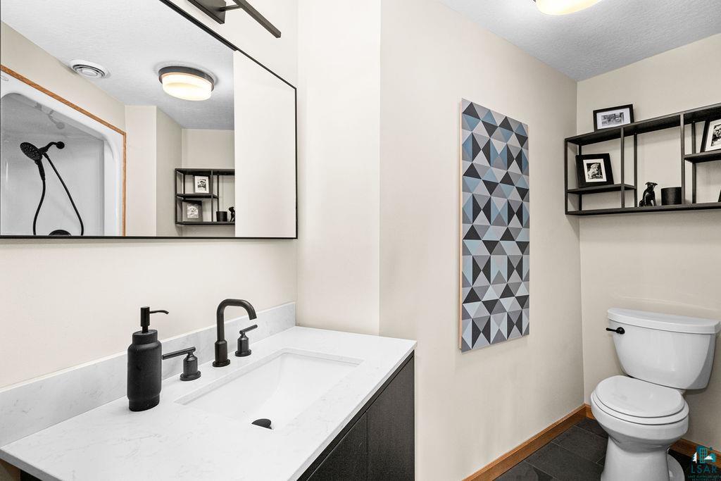 4856 Kingston Street Duluth, MN 55804 - Photo 49 of 88 Bathroom featuring a white rectangular undermount sink, a white countertop, dark flat-panel cabinetry, and matte black plumbing fixtures