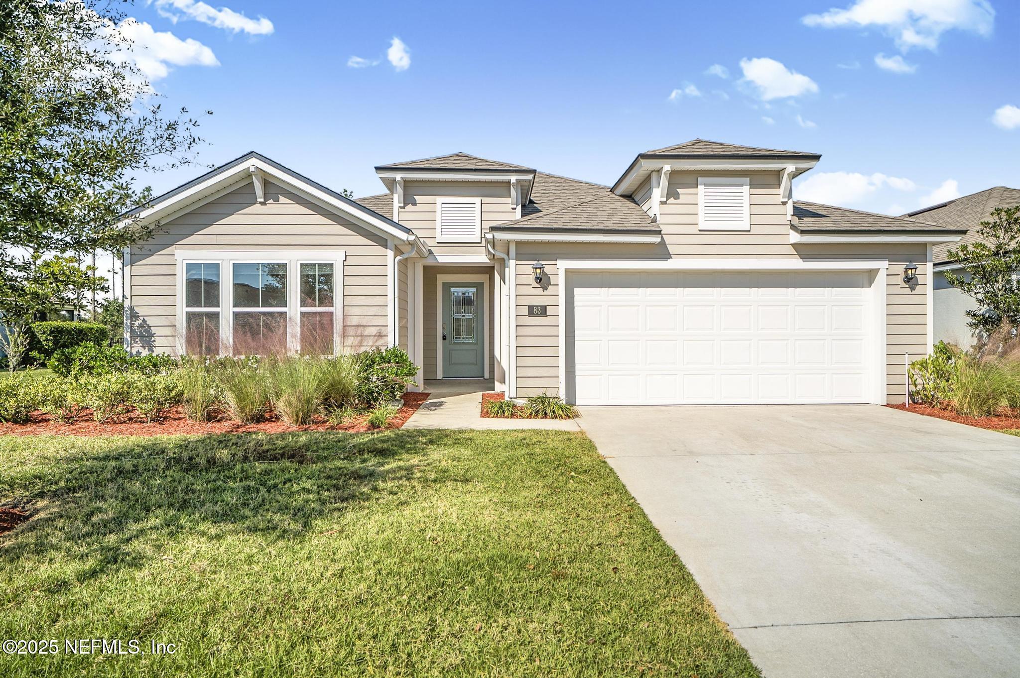 83 Hummingbird Court Palm Coast, FL 32164 - Photo 1 of 70 a front view of a house with a yard and garage