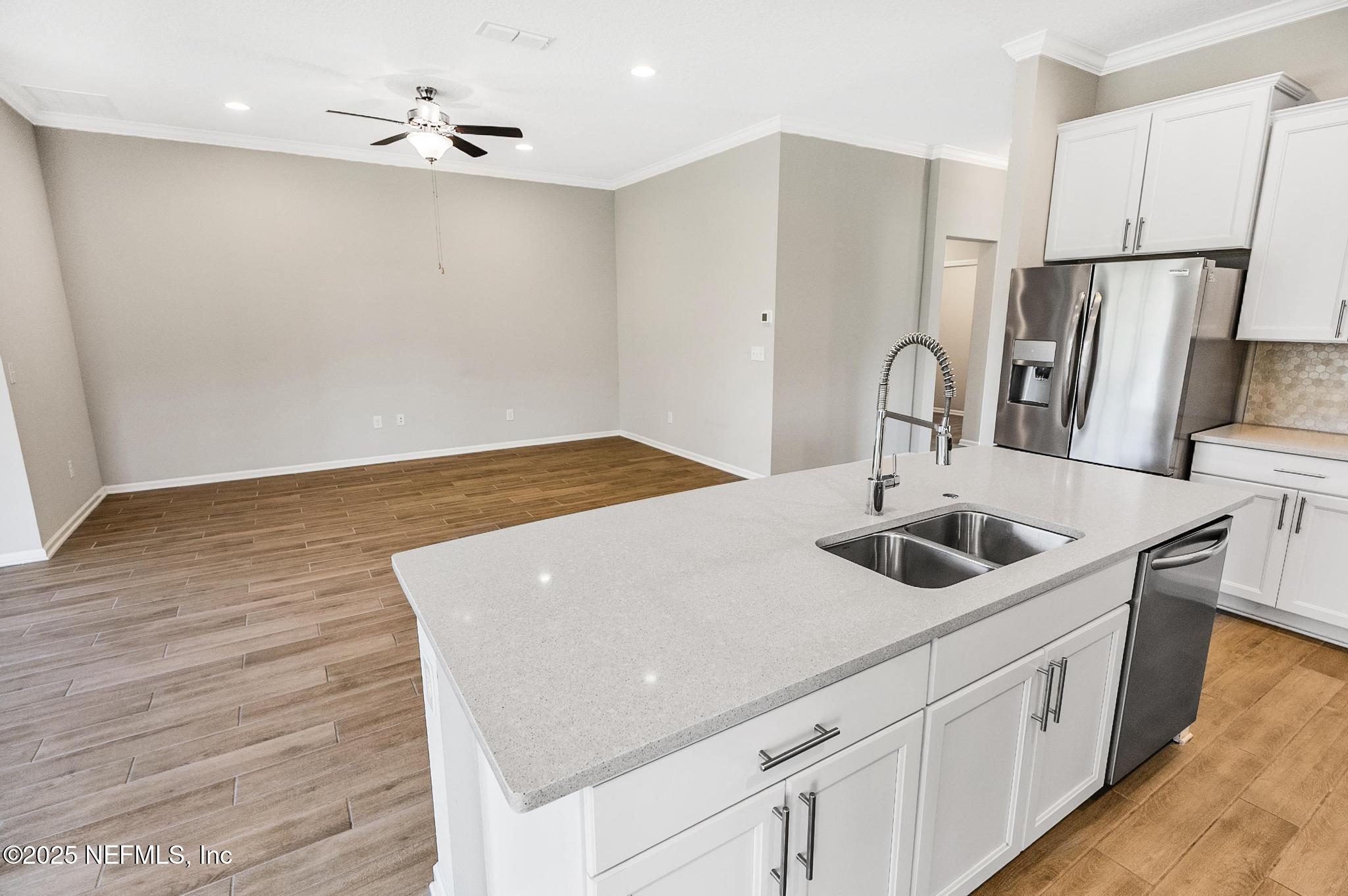 83 Hummingbird Court Palm Coast, FL 32164 - Photo 13 of 70 a kitchen with stainless steel appliances granite countertop a sink and a refrigerator